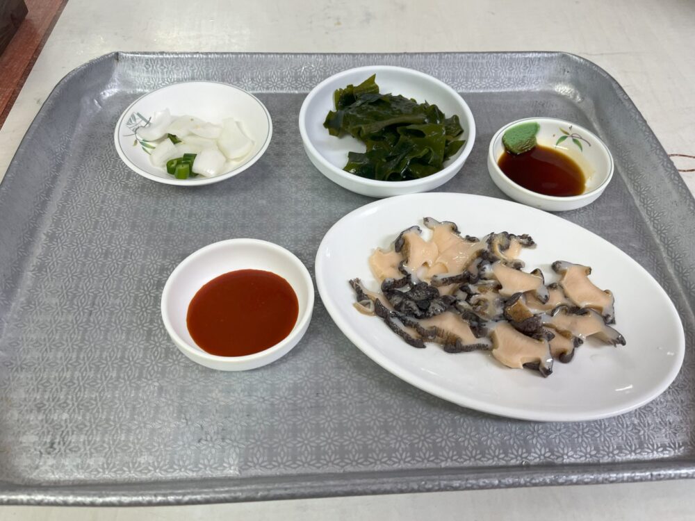 城山日出峯（ソンサンイルチュルボン）でアワビの刺身