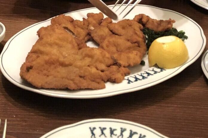 老舗レストランで提供された、お皿を覆い尽くすほど大きなウィーナー・シュニッツェル