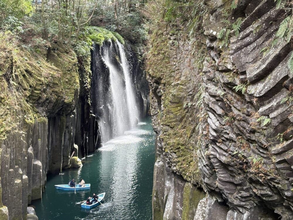 真名井の滝のすぐそばまで近づく貸しボートの風景。峡谷の高さと水の勢いを間近で感じられる