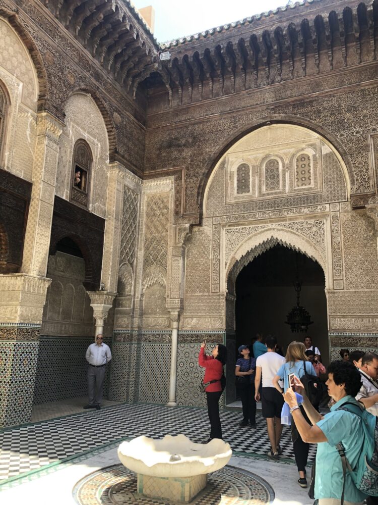 ブー・イナニア・マドラサ内部の、幾何学模様のタイルと繊細な木彫り装飾が美しい中庭