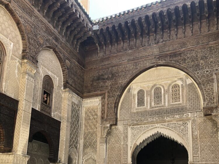 ブー・イナニア・マドラサ内部の、幾何学模様のタイルと繊細な木彫り装飾が美しい中庭