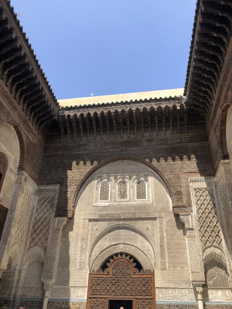 ブー・イナニア・マドラサ内部の、幾何学模様のタイルと繊細な木彫り装飾が美しい中庭