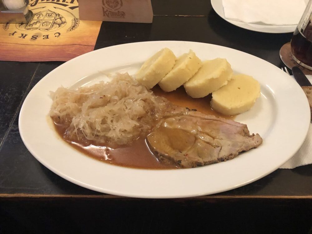 柔らかいローストポークにクネドリーキとザワークラウトが添えられたチェコ料理
