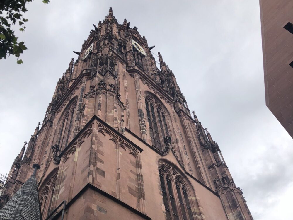 フランクフルトの青空に高くそびえ立つ赤茶色のレンガ造りが美しい聖バルトロメウス大聖堂の外観