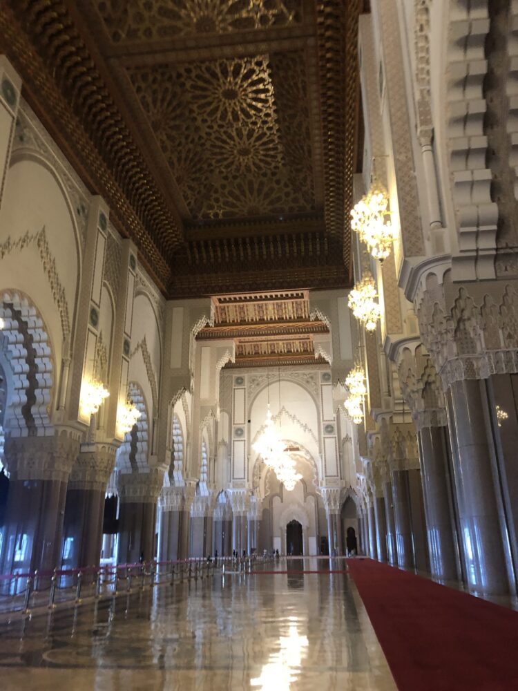 ハッサン2世モスクの内部。精巧な彫刻が施された天井やシャンデリアが輝く、広大な礼拝の間