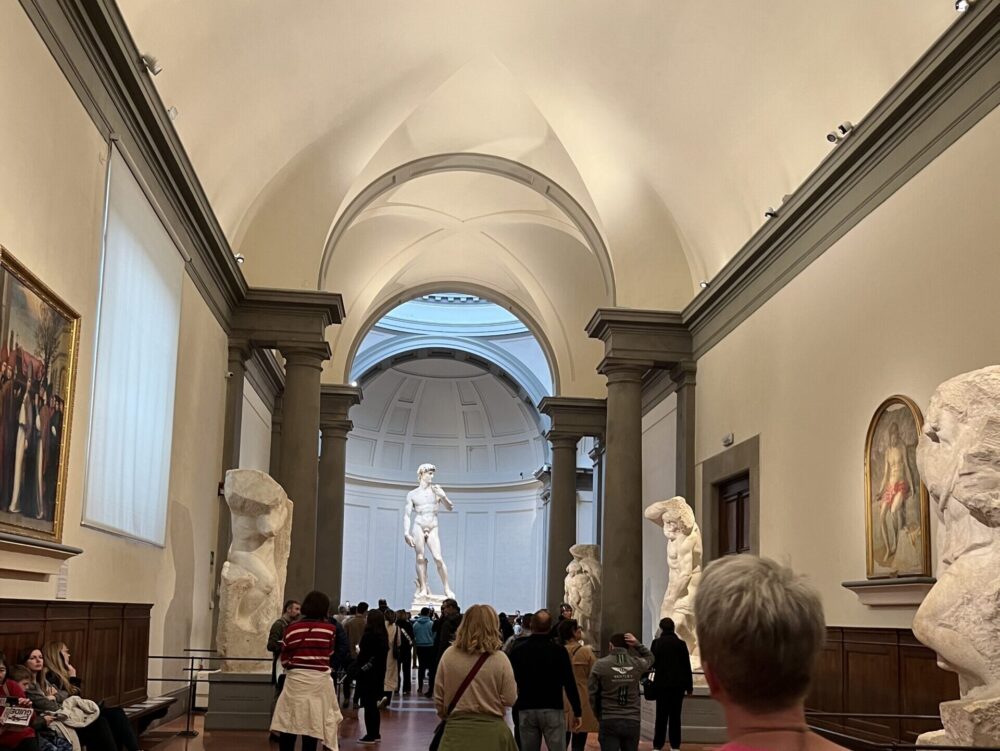 アカデミア美術館のハイライト、ミケランジェロの《ダビデ像》。その堂々たる姿に圧倒されながら、通路に並ぶ未完の囚人像