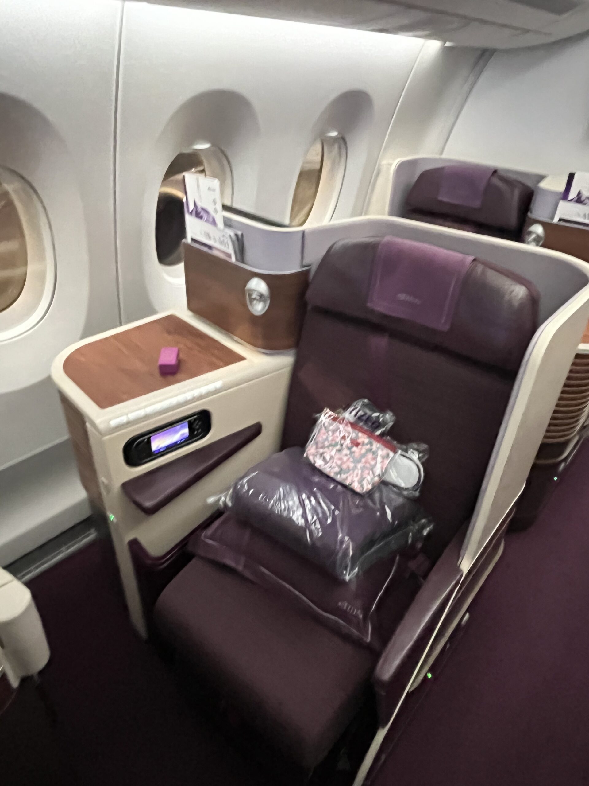 タイ航空エアバスA350のビジネスクラスにある、紫を基調とした落ち着いたデザインの機能的なスタッガード型シート