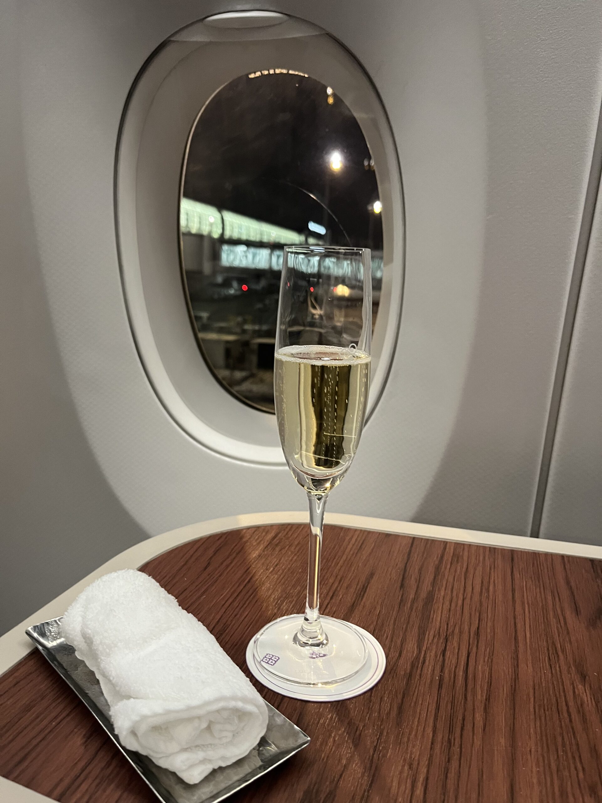 タイ航空ビジネスクラスの機内で、離陸前に提供される冷えたウェルカムシャンパン「ペリエ・ジュエ」のグラス。