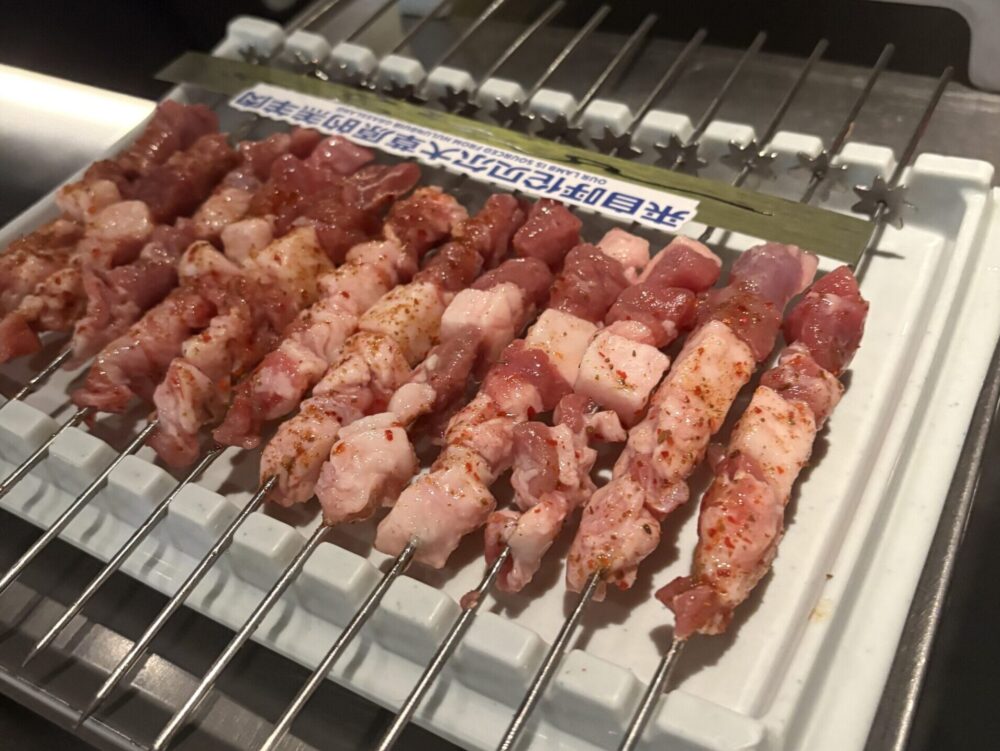 焼く前の羊肉串と串に刺さった生のラム肉